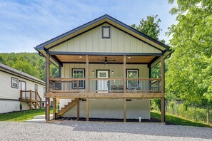 Un bĂątiment Ă deux Ă©tages dotĂ© dâun balcon, dâune terrasse en bois et dâun escalier menant Ă lâĂ©tage supĂ©rieur.
