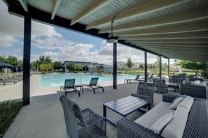 A covered outdoor area with a pool, lounge chairs, and seating arrangements. - Premium Ontario Home w/ Resort-style Perks! (Ontario)