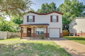 A two-story house with a front porch, a garage, and a small front yard. - Pets Welcome! Wilmer Haven w/ Private Yard & Patio (Wilmer)