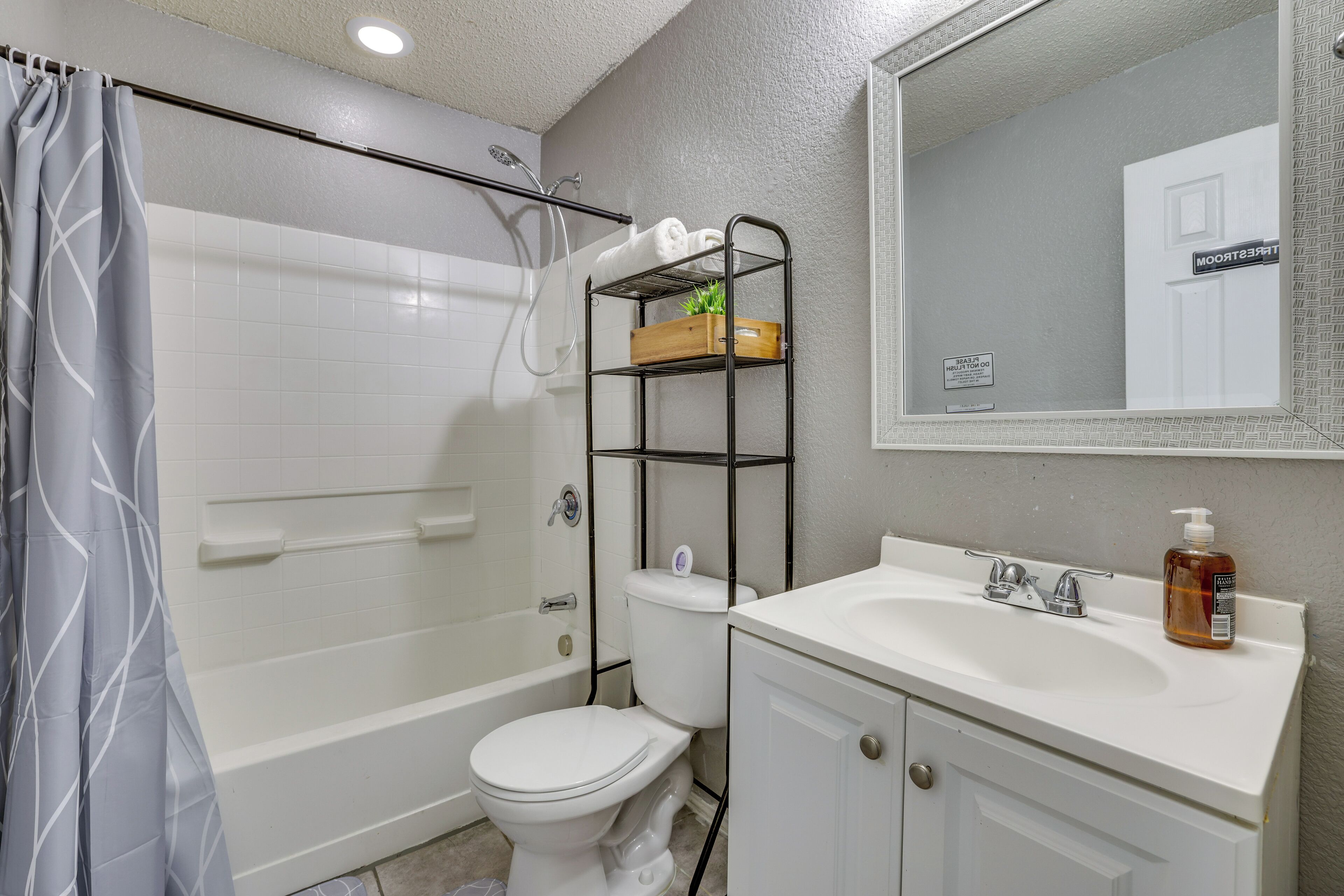 A bathroom with a shower, toilet, and sink.