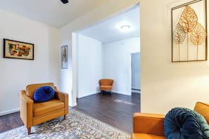 A modern living room with a brown leather sofa, a patterned rug, and a blue pillow. - 4BR Griffin Home Walk Downtown Large Driveway (Griffin)