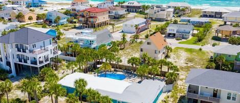 Un quartier résidentiel situé sur la côte, avec des maisons, une piscine et une vue sur l’océan.