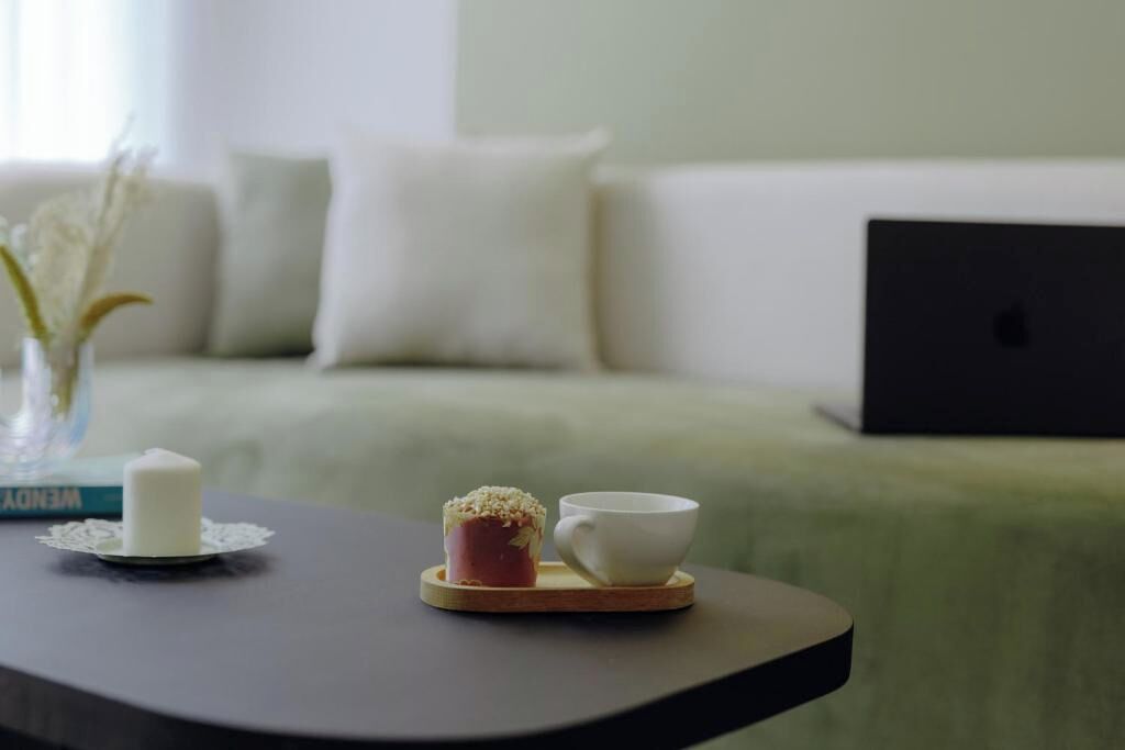 Un tavolo con una candela, un muffin e una tazza.