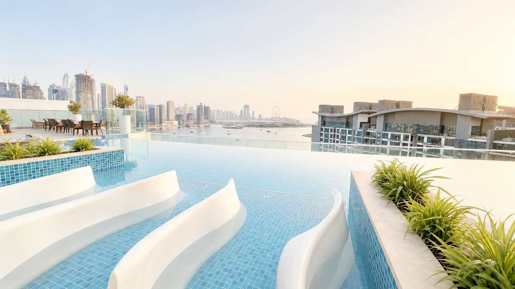 A rooftop infinity pool with a city skyline view, modern architecture, and outdoor seating.