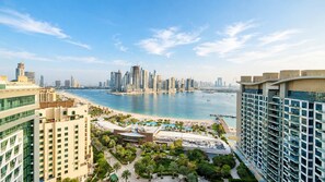 A high-rise hotel overlooking a beach with a city skyline in the background. - Rentico | Infinity Pool Studio on Palm Jumeirah (Dubai)