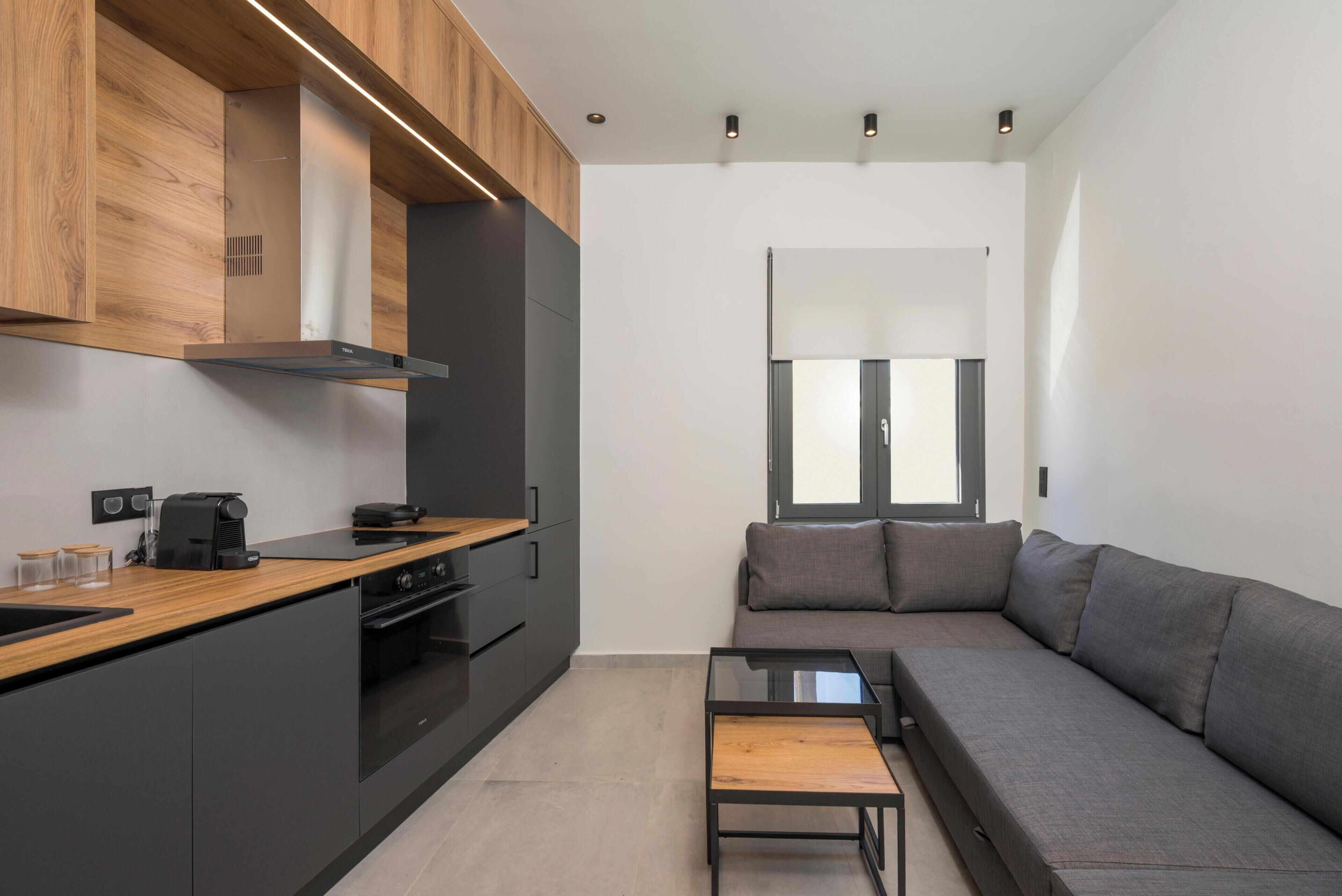 A modern kitchen with wooden cabinets, a built-in oven, and a coffee maker.