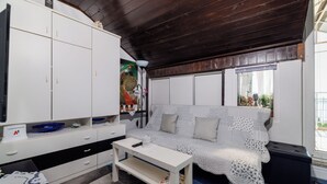 Ein Zimmer mit einem weißen Sofa, einem weißen Tisch und einer weißen Kommode.