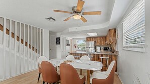 Una cucina moderna con mobili in legno, un forno a microonde integrato e una grande isola con sgabelli da bar.