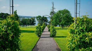 A pathway leading to a gazebo with a view of a lake and trees.