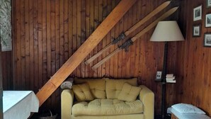 Un interior de madera con un sofá, una lámpara y un ventilador de techo.