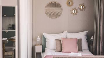 A neatly arranged bedroom with a bed, bedside tables, and a nightstand.