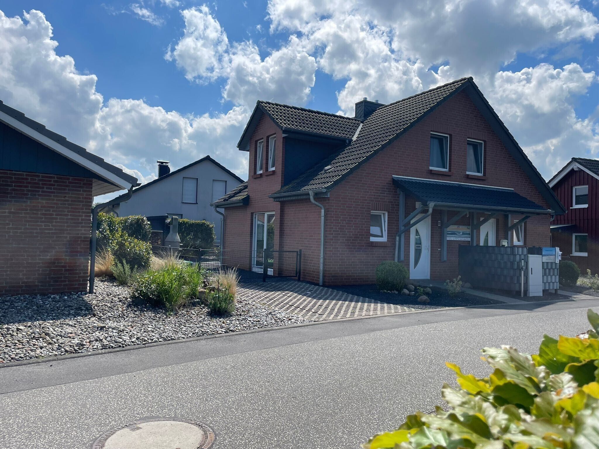 A residential area with houses, a paved driveway, and a clear sky.. Vacation home \"sanddüne\" apartment lee (left) in zierow