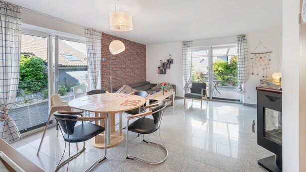 Una cucina moderna con zona pranzo, ampie finestre e camino.