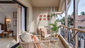 A balcony with wicker furniture, a potted plant, and a view of the surrounding area. - Casa Calma Scenic 3BR Duplex With Jacuzzi (Oxel)