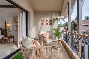 A balcony with wicker furniture, a potted plant, and a view of the surrounding area. - Casa Calma Scenic 3BR Duplex With Jacuzzi (Oxel)