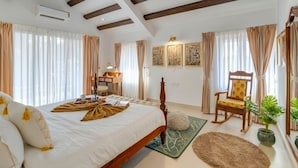 A bedroom with a bed, a chair, a desk, and a potted plant. - Casa Calma Scenic 3BR Duplex With Jacuzzi (Oxel)