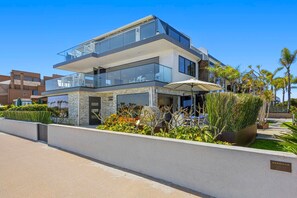 Ein modernes, zweistöckiges Haus mit Balkon, Garage und einem gepflegten Garten.