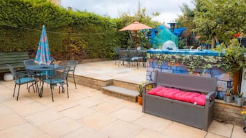 An outdoor patio with a dining area, a bar, and a seating bench.