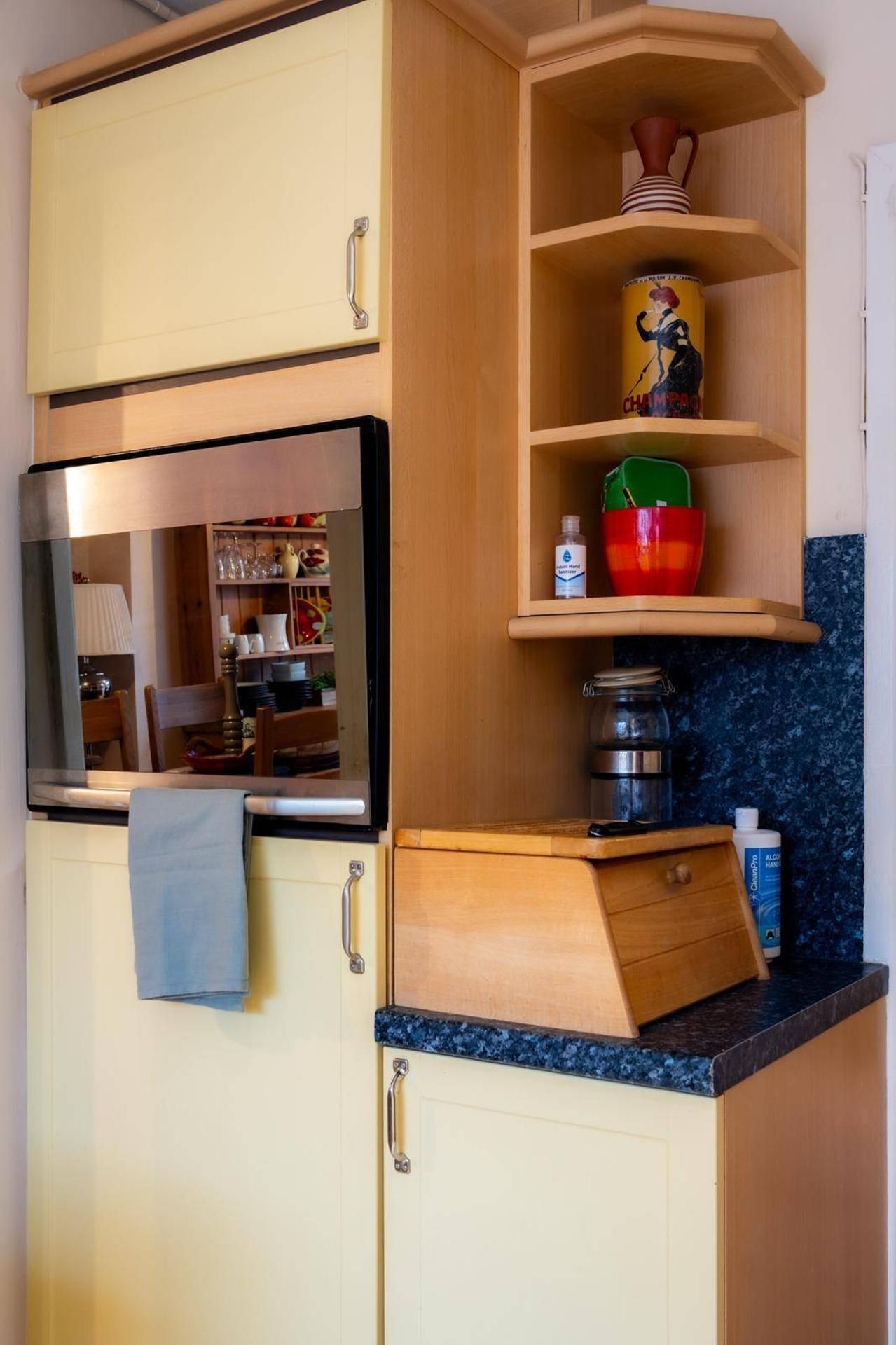 A compact kitchen with a built-in oven, a microwave, and a small countertop.