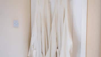 A white door with a metal towel rack holding several white towels.