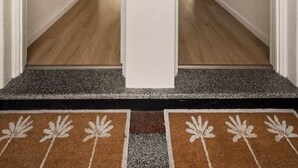 Um corredor com uma porta dupla que dá para uma sala de jantar.