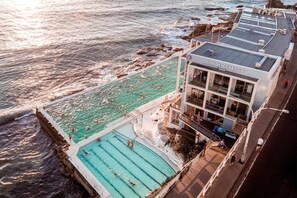 Take a refreshing dip at Bondi Icebergs Pool, an iconic oceanfront swimming club featuring stunning views of the crashing waves and sparkling turquoise waters. - The Hideaway | Coastal Escape with Winter Sun & Fine Dining (North Bondi)