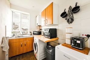 A compact kitchen with a washing machine, a toaster, and a coffee maker. - Entire apartment in Brixton (London)