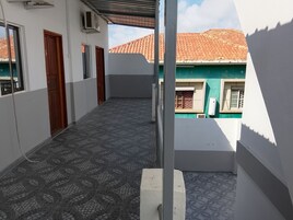 Um corredor com piso estampado, uma porta e um aparelho de ar condicionado.
