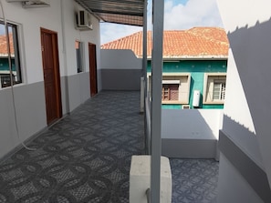 A corridor with patterned flooring, a door, and an air conditioning unit.