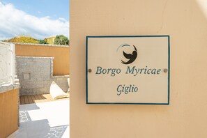 A sign with a logo and text 'Borgo Myricae Giglio' on a wall.