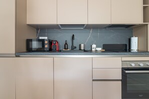 A modern kitchen with a built-in oven, microwave, and coffee maker.