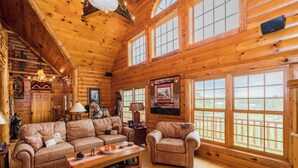 A log cabin interior with a wooden floor, a sofa set, a coffee table, and large windows with a view. - Unique Log Cabin, Hudson Riverfront, minutes to Saratoga (Melrose)