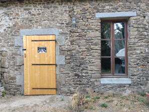 A stone building with a wooden door and a window. - La Ferme du Mont Rochard (Sainte-Gemmes-le-Robert)