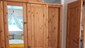 Une chambre à coucher avec un lit, une armoire en bois et une porte.