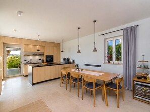 Uma cozinha moderna com ilha central, armários de madeira e iluminação pendente.