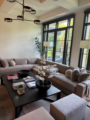 Un salon moderne avec un canapé, une table basse et une orchidée en pot.