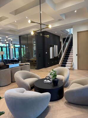 A modern living room with a sofa set, a coffee table, and a staircase. - Luxury home in heart of Toronto. Brand new and amazing amenities. Resort like (Toronto)