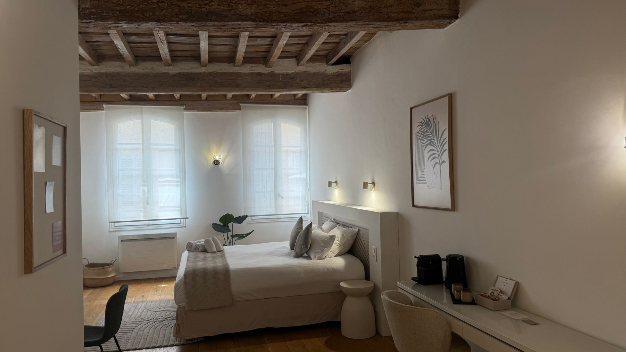 A bedroom with a bed, bedside table, and a window.