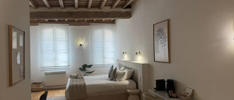 A bedroom with a bed, bedside table, and a window.