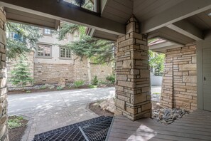 A covered outdoor area with stone walls, a metal grate, and a paved path leading to a building. - Aspen Ridge 25 3 Bedroom Townhouse (Telluride)