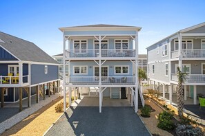 Un immeuble à plusieurs étages doté de balcons, d’une galerie couverte et surplombant un ciel dégagé.