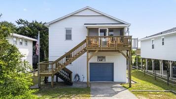 A two-story house with a wooden deck and a garage.