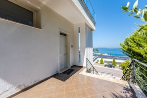 Ein Balkon mit Meerblick, eine Tür und Solaranlagen auf dem Dach.