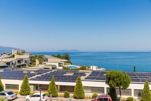 Ein Küstengebäude mit Solaranlage, Schwimmbad und Parkplatz.