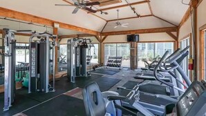 A gym with exercise equipment, a ceiling fan, and large windows. - 30a Getaway 3 Bedroom Condo (Santa Rosa Beach)