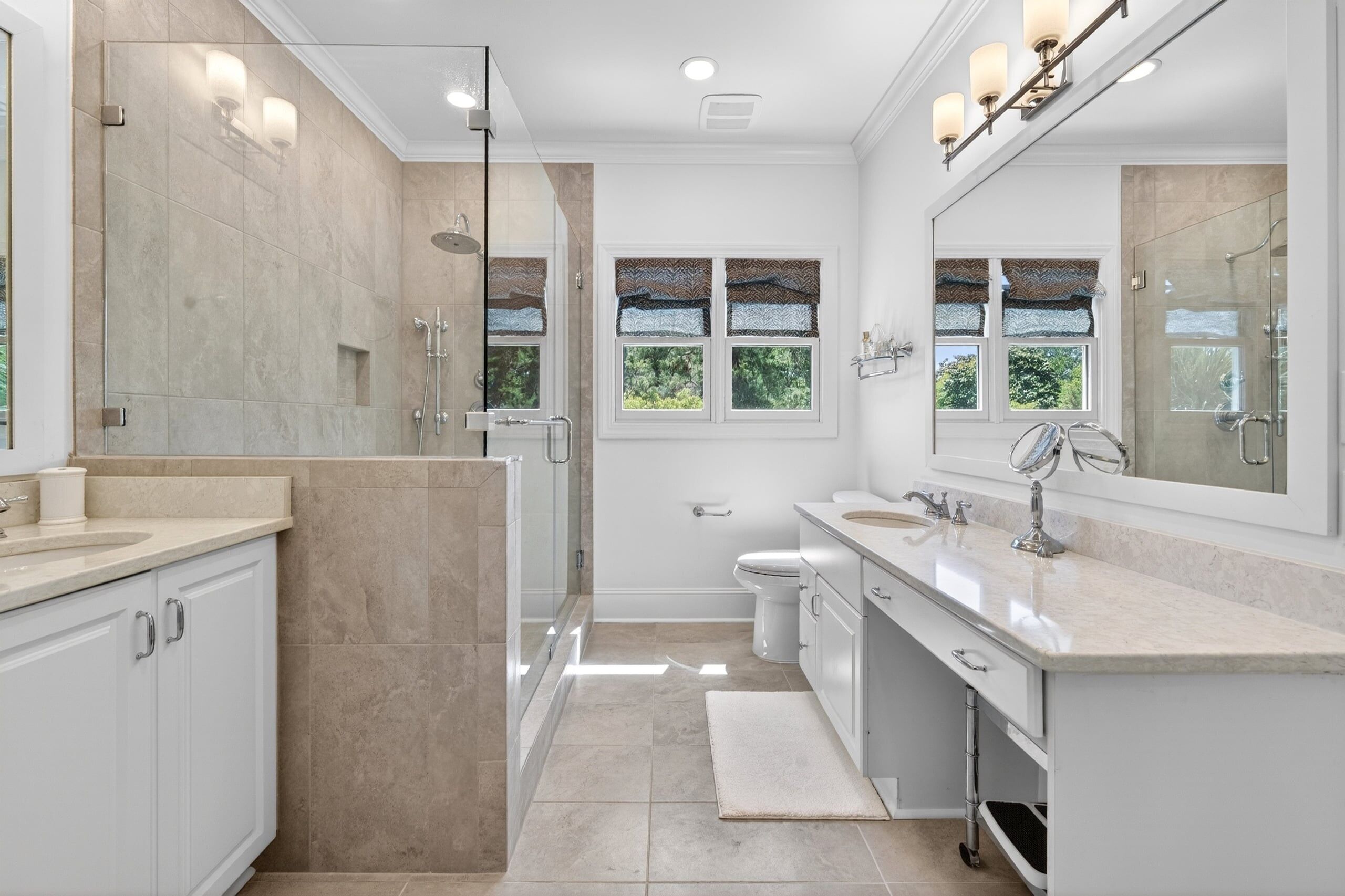 A modern bathroom with a walk-in shower, a toilet, and a sink.