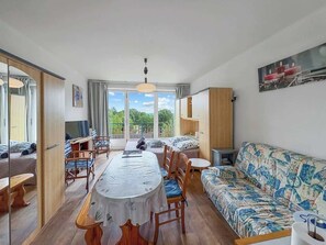 Et moderne værelse med spisebord, stole, sofa og fjernsyn.