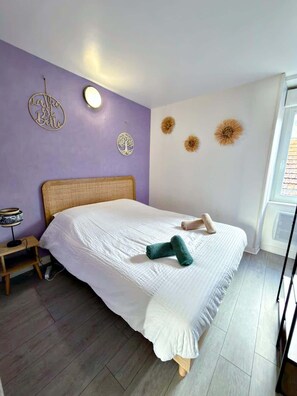 Une chambre à coucher comprenant un lit, une table de chevet, une lampe et des éléments décoratifs sur les murs.