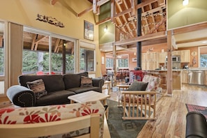 A spacious living area with a sofa, chairs, and a dining table. - A-frame Home With Deck & Bbq - Vh #223 2 Bedroom Cabin (Arnold)