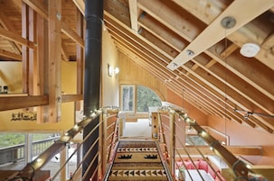 Un interior de madera con una escalera que lleva a un balcón.